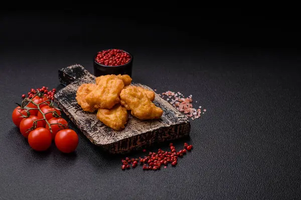 Delicious fresh crispy chicken nuggets on a dark concrete background. Unhealthy food, fast food