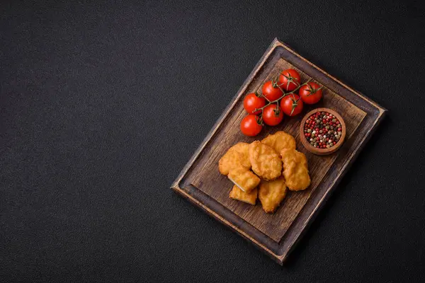 Koyu beton arka planda lezzetli çıtır tavuk nuggetları. Sağlıksız yemek, fast food