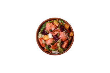 Somon, domates, salatalık, salatalık, otlar, kabak çekirdekleri, seramik tabakta tuz ve baharatlarla dolu lezzetli bir salata.