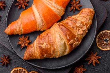 Lezzetli taze, gevrek Fransız kruvasanları. Koyu beton bir arka planda tatlı dolgu.