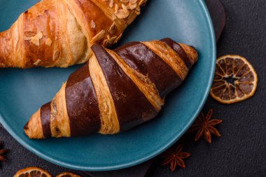 Lezzetli taze, gevrek Fransız kruvasanları. Koyu beton bir arka planda tatlı dolgu.