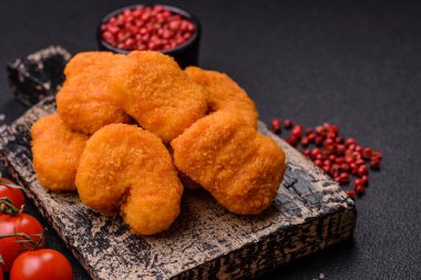 Delicious fresh crispy chicken nuggets on a dark concrete background. Unhealthy food, fast food