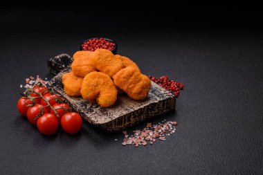 Delicious fresh crispy chicken nuggets on a dark concrete background. Unhealthy food, fast food