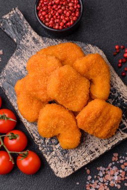 Delicious fresh crispy chicken nuggets on a dark concrete background. Unhealthy food, fast food