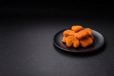 Delicious fresh crispy chicken nuggets on a dark concrete background. Unhealthy food, fast food
