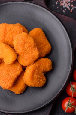 Delicious fresh crispy chicken nuggets on a dark concrete background. Unhealthy food, fast food