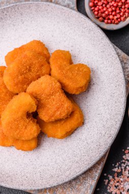 Delicious fresh crispy chicken nuggets on a dark concrete background. Unhealthy food, fast food
