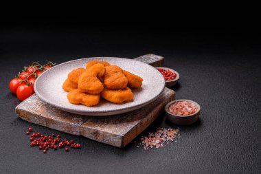 Delicious fresh crispy chicken nuggets on a dark concrete background. Unhealthy food, fast food