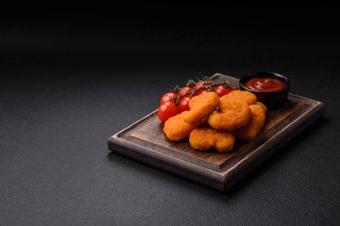 Delicious fresh crispy chicken nuggets on a dark concrete background. Unhealthy food, fast food