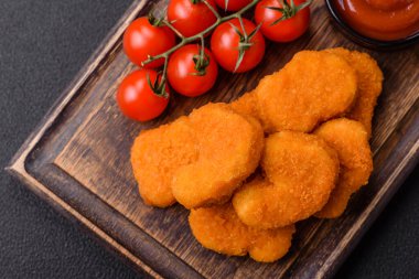 Delicious fresh crispy chicken nuggets on a dark concrete background. Unhealthy food, fast food