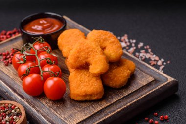 Delicious fresh crispy chicken nuggets on a dark concrete background. Unhealthy food, fast food