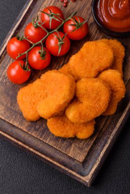 Delicious fresh crispy chicken nuggets on a dark concrete background. Unhealthy food, fast food