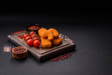 Delicious fresh crispy chicken nuggets on a dark concrete background. Unhealthy food, fast food