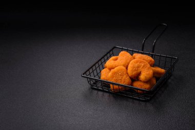Delicious fresh crispy chicken nuggets on a dark concrete background. Unhealthy food, fast food