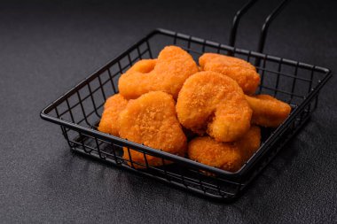 Delicious fresh crispy chicken nuggets on a dark concrete background. Unhealthy food, fast food