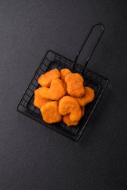 Delicious fresh crispy chicken nuggets on a dark concrete background. Unhealthy food, fast food