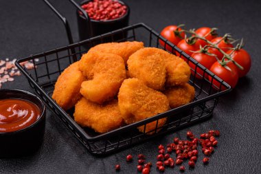 Delicious fresh crispy chicken nuggets on a dark concrete background. Unhealthy food, fast food