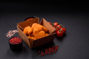Koyu beton arka planda lezzetli çıtır tavuk nuggetları. Sağlıksız yemek, fast food