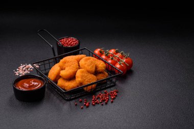 Delicious fresh crispy chicken nuggets on a dark concrete background. Unhealthy food, fast food