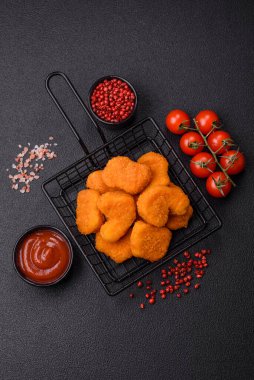 Delicious fresh crispy chicken nuggets on a dark concrete background. Unhealthy food, fast food