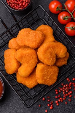 Delicious fresh crispy chicken nuggets on a dark concrete background. Unhealthy food, fast food