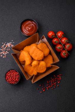 Koyu beton arka planda lezzetli çıtır tavuk nuggetları. Sağlıksız yemek, fast food