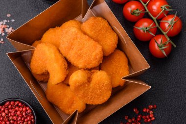 Delicious fresh crispy chicken nuggets on a dark concrete background. Unhealthy food, fast food