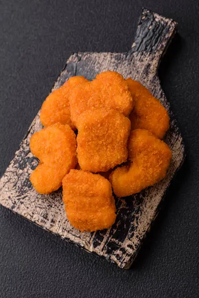 Koyu beton arka planda lezzetli çıtır tavuk nuggetları. Sağlıksız yemek, fast food