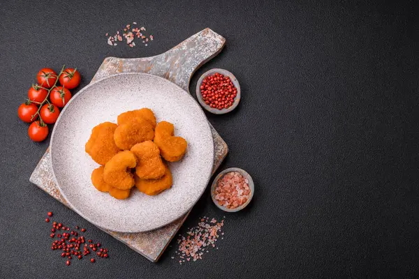 Delicious fresh crispy chicken nuggets on a dark concrete background. Unhealthy food, fast food