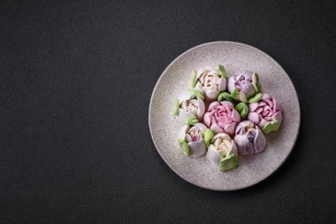 Lale tomurcukları şeklinde güzel, lezzetli marşmelovlar. Koyu beton bir arka planda.