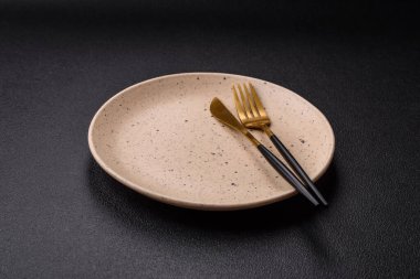 Çatal bıçak, bıçak ve kaşık koyu dokulu beton arka planda. Mutfak eşyaları ve aksesuarları.