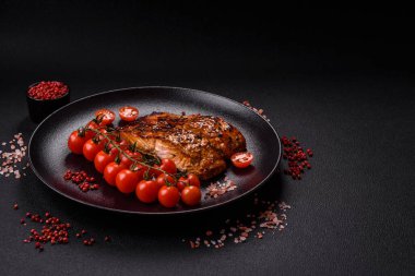 Sos ve susamlı lezzetli kırmızı somon balığı, koyu beton arka planda baharatlar ve otlar.