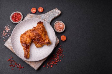 Lezzetli ızgara tavuk budu ya da koyu beton arka planda tuz ve baharatlı çeyreklik.