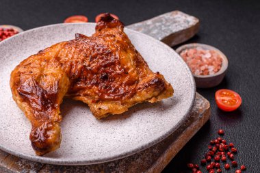 Lezzetli ızgara tavuk budu ya da koyu beton arka planda tuz ve baharatlı çeyreklik.