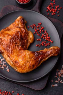 Lezzetli ızgara tavuk budu ya da koyu beton arka planda tuz ve baharatlı çeyreklik.