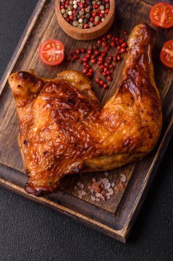 Lezzetli ızgara tavuk budu ya da koyu beton arka planda tuz ve baharatlı çeyreklik.