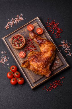 Lezzetli ızgara tavuk budu ya da koyu beton arka planda tuz ve baharatlı çeyreklik.