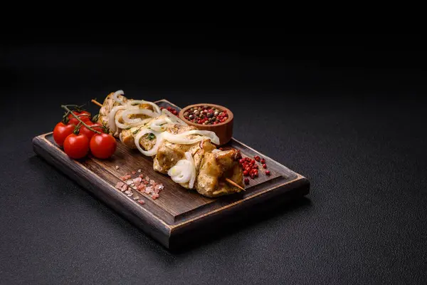 Delicious fresh chicken meat kebab with salt, spices and herbs on a dark concrete background