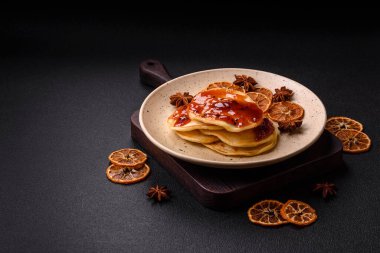 Koyu beton bir zeminde seramik tabakta lezzetli reçelli taze pişmiş krep.