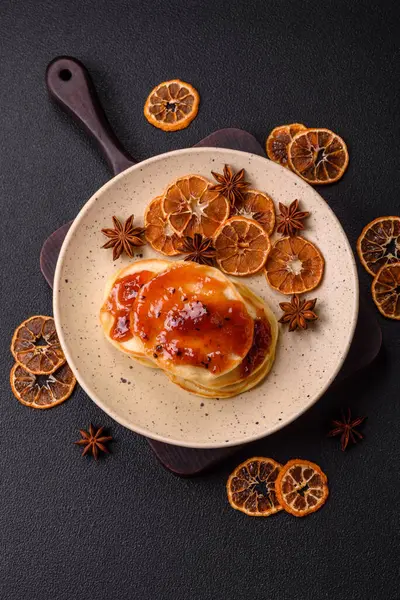 Koyu beton bir zeminde seramik tabakta lezzetli reçelli taze pişmiş krep.