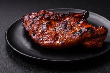 Karanlık bir arka planda taze sulu lezzetli biftek. Baharatlı ve otlu et yemeği.