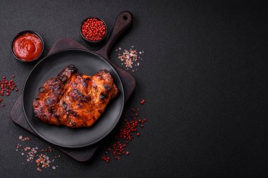 Karanlık bir arka planda taze sulu lezzetli biftek. Baharatlı ve otlu et yemeği.