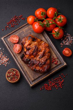 Karanlık bir arka planda taze sulu lezzetli biftek. Baharatlı ve otlu et yemeği.