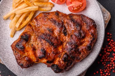 Karanlık bir arka planda taze sulu lezzetli biftek. Baharatlı ve otlu et yemeği.