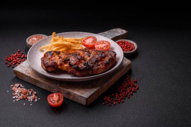 Karanlık bir arka planda taze sulu lezzetli biftek. Baharatlı ve otlu et yemeği.