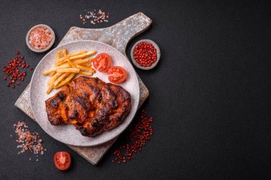 Karanlık bir arka planda taze sulu lezzetli biftek. Baharatlı ve otlu et yemeği.