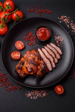 Karanlık bir arka planda taze sulu lezzetli biftek. Baharatlı ve otlu et yemeği.