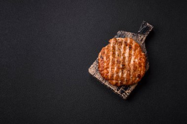 Lezzetli taze ızgara tavuk filetosu, esrarlı baharatlar ve çimento kaplı otlar. Ateşte pişirilmiş bir tabak.