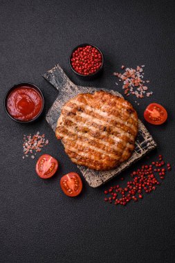 Lezzetli taze ızgara tavuk filetosu, esrarlı baharatlar ve çimento kaplı otlar. Ateşte pişirilmiş bir tabak.