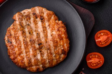 Lezzetli taze ızgara tavuk filetosu, esrarlı baharatlar ve çimento kaplı otlar. Ateşte pişirilmiş bir tabak.